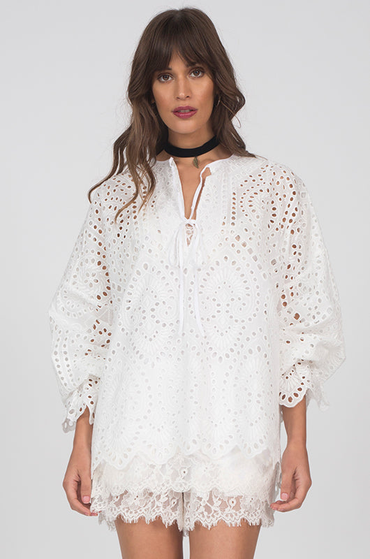 Model is wearing the Adele Cotton Oversized Top in white. Worn with the Floral Lace Cami in white and Coco Lace Shorts in white.