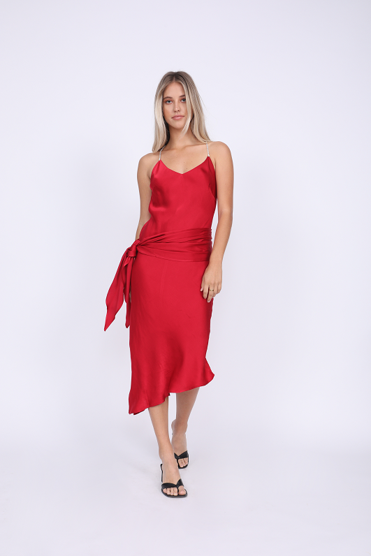 Model is wearing the Aimee Slip Dress in fiery red with matching sash worn wide on the waist. Also worn with sandals.