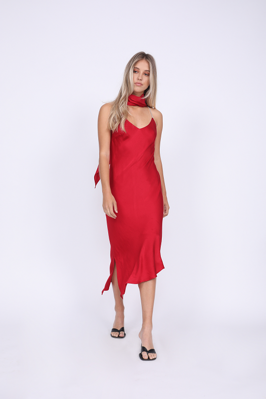 Model is wearing the Aimee Slip Dress in fiery red with matching sash as a scarf. Worn with sandals.
