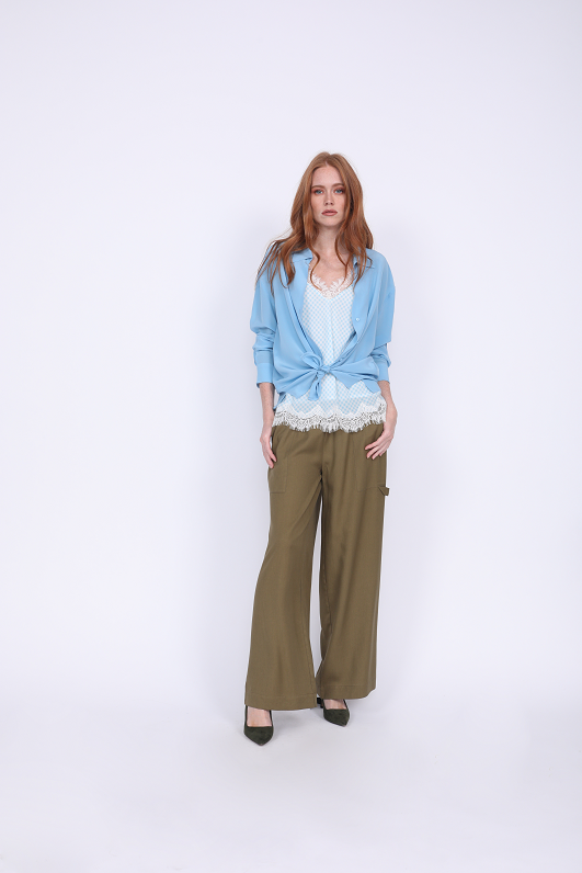 Model is wearing the Anne Marie Silk Cami in baby blue/off white with a baby blue button up shirt, open, cuffed, and tied at the front, and the Tencel Cargo Wide Leg Pant in olive. Worn with emerald green, suede, pointed toe high heels.
